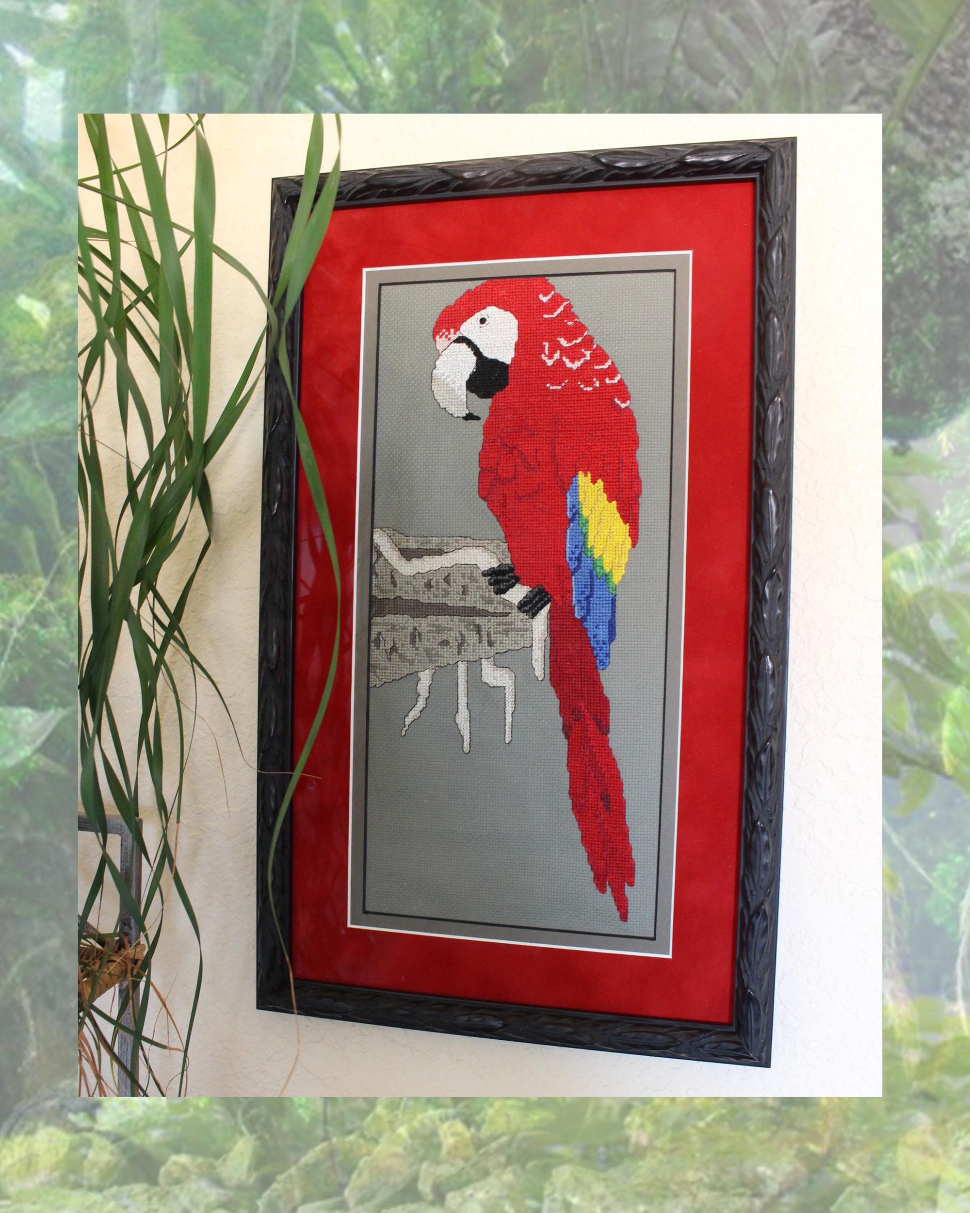 Framed picture with red matting and brown frame of scarlet macaw cross stitch completed project.  Red Scarlet Macaw on Clay Cliffs cross stitch pattern PDF digital download for sale buy purchase at Raspberry Lane Crafts www.raspberrylanecrafts.com by Wendy Christine.  Thanks for your purchase!