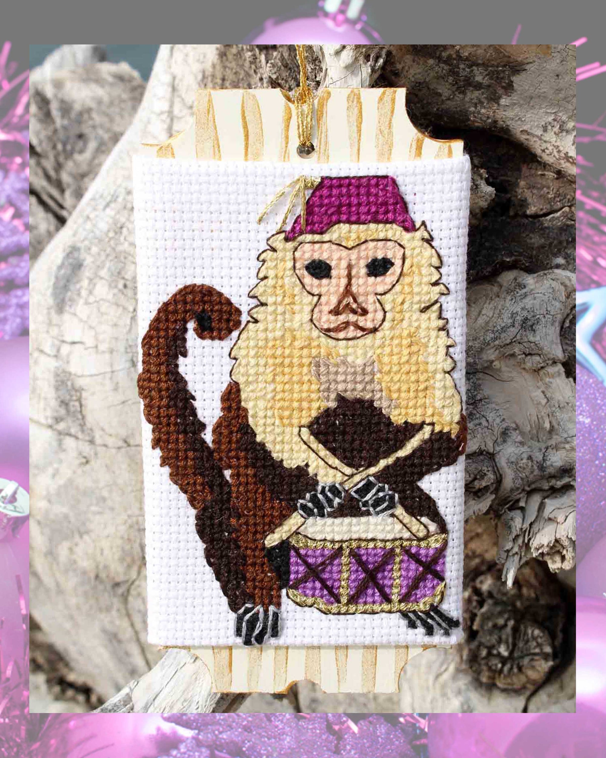 Tan and brown Capuchin monkey with purple fez hat with gold tassel and purple drum with sticks cross stitch pattern for Christmas ornaments with gold thread and gold paint decorates a ticket shaped wooden paintable ornament by Wendy Christine of Raspberry Lane Crafts for sale purchase buy digital PDF download downloadable no shipping international