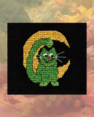 Moony Cat Halloween Cross-Stitch Pattern features a cute green cat with crescent moon background as part of the Halloween Night Cross Stitch Pattern Collection by Wendy Christine at www.raspberrylanecrafts.com for sale buy purchase PDF download digital file now for sale