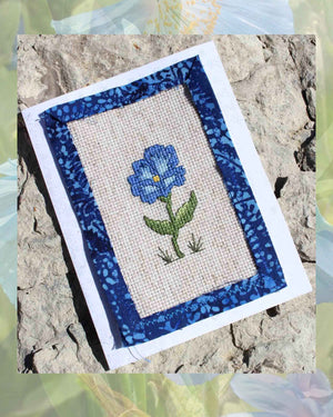 Blue morning glory cross stitch pattern with greeting card project directions features a blue flower with yellow gold center and green leaves with grass blades is one of four patterns included in Antique Flower Cross-Stitch Pattern available now for sale purchase buy at Raspberry Lane Crafts by Wendy Christine American artist and designer.  Not available at etsy.com facebook.com or amazon.com.  Original cross-stitch patterns for sale internationally