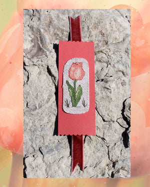 Peach tulip bookmark cross-stitch pattern features an apricot flower with green leaves stem and grass blades with bookmark directions is part of four flower cross stitch patterns in the Antique Flower Cross Stitch Pattern download PDF digital file for sale buy purchase at Raspberry Lane Crafts www.raspberrylanecrafts.com by American artist Wendy Christine.  I am so grateful for your purchase