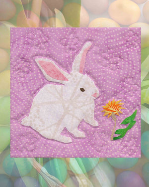 Adorable white Easter bunny with yellow dandylion flower on spotted purple lavendar fabric is one  6 x 6 inches block of the Blooming Spring Quilt Wallhanging pattern for sale at Raspberry Lane Crafts.  Pattern designed by Wendy Christine American artist for sale digital PDF download no shipping