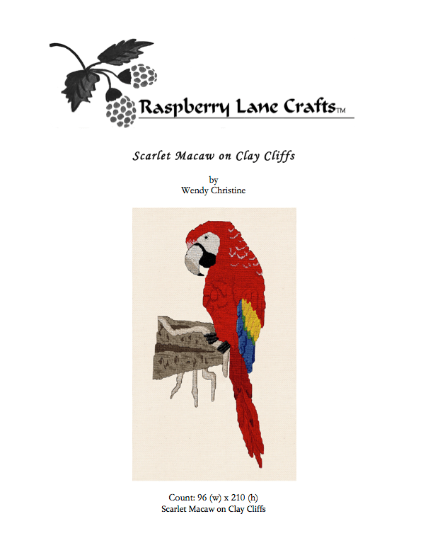 Framed picture with red matting and brown frame of scarlet macaw cross stitch completed project.  Red Scarlet Macaw on Clay Cliffs cross stitch pattern PDF digital download for sale buy purchase at Raspberry Lane Crafts www.raspberrylanecrafts.com by Wendy Christine.  Thanks for your purchase!